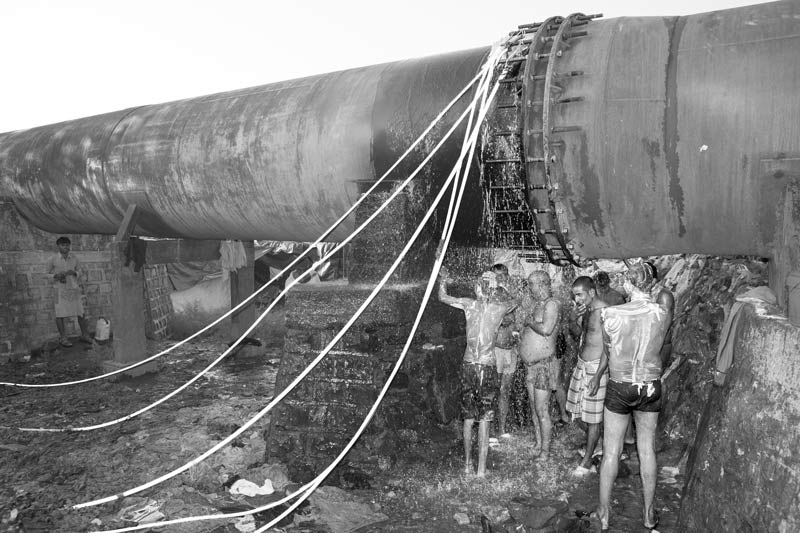 Human Right to Water in Mumbai - Using a pipeline leakage as a public bathroom near an unserved slum